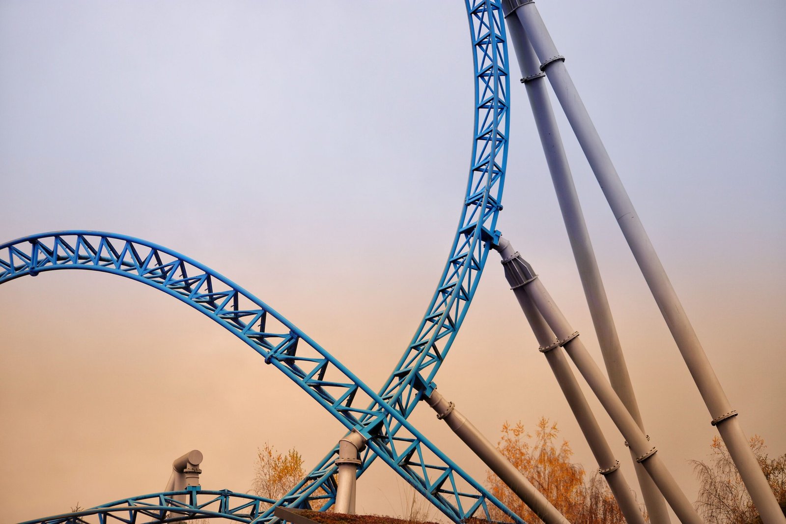 Home Vertical steel roller coaster track with sunset sky in Rust, Germany. Captivating amusement park structure.
